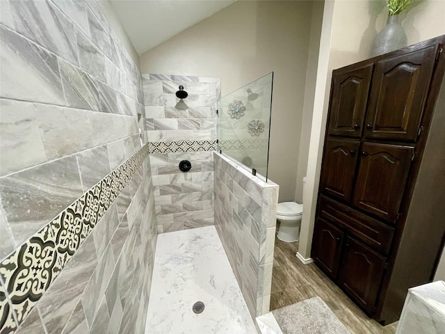 full bath with toilet, vaulted ceiling, wood finished floors, and a walk in shower