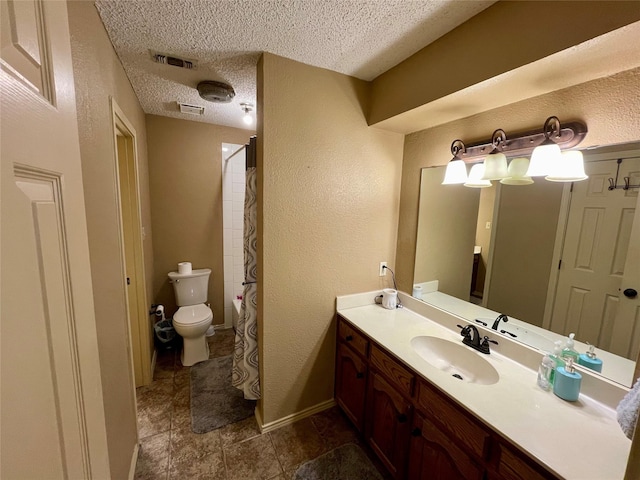 full bathroom featuring visible vents, a textured wall, toilet, vanity, and a textured ceiling