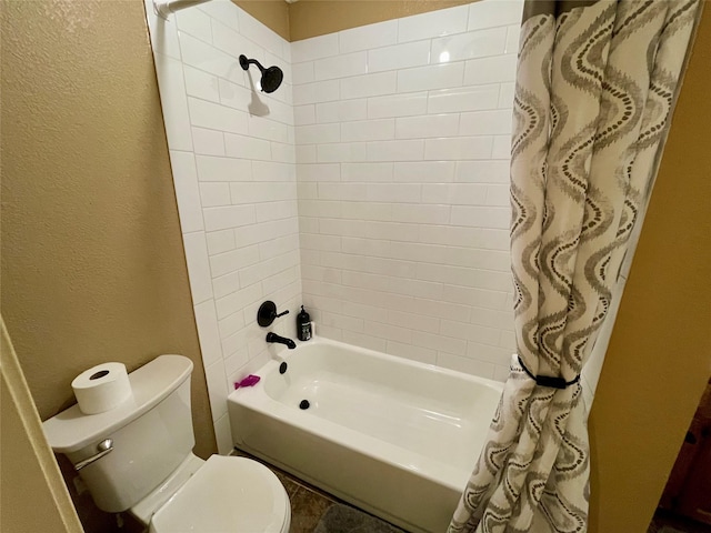 bathroom with toilet, shower / bath combo, and a textured wall