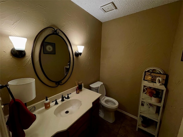 bathroom with a textured ceiling, a textured wall, vanity, and toilet