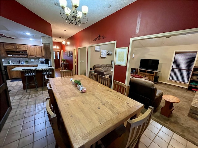 dining room featuring ceiling fan with notable chandelier, lofted ceiling, a textured ceiling, and light tile patterned floors