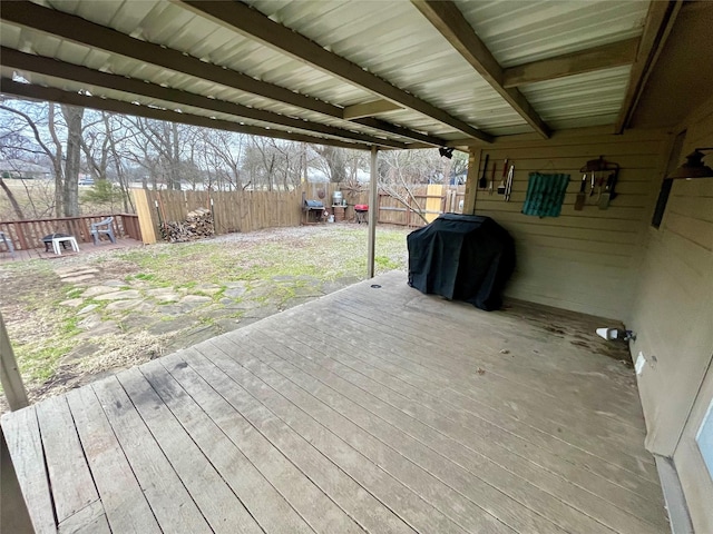 wooden deck featuring a fenced backyard, a carport, and area for grilling