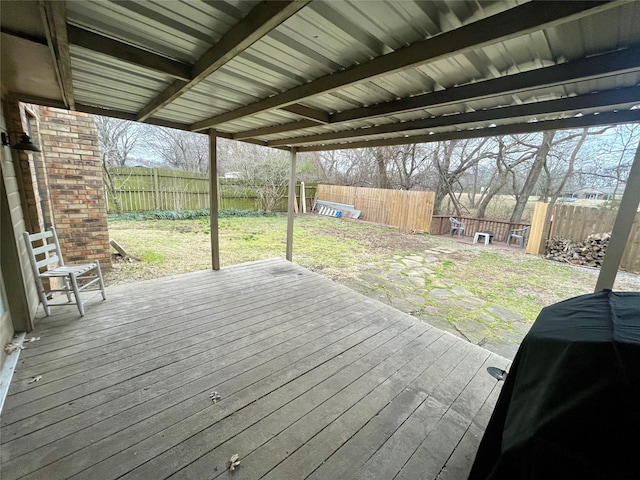 wooden terrace featuring a fenced backyard, a lawn, and grilling area