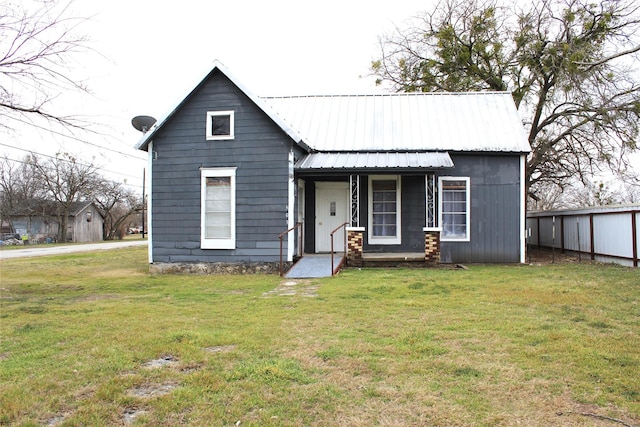 view of front facade featuring metal roof and a front yard