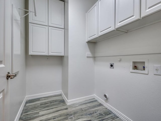 clothes washing area featuring cabinet space, baseboards, hookup for a gas dryer, hookup for an electric dryer, and washer hookup