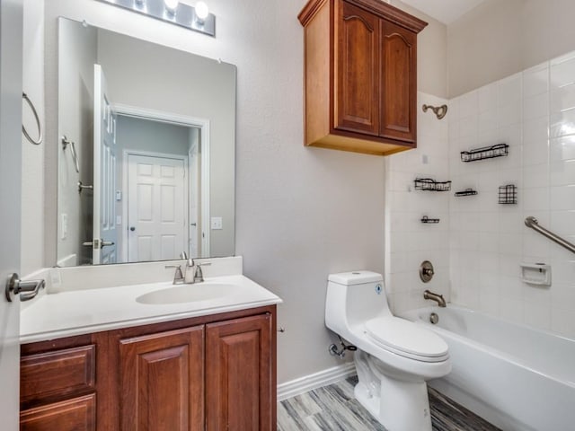 bathroom featuring bathing tub / shower combination, toilet, vanity, wood finished floors, and baseboards