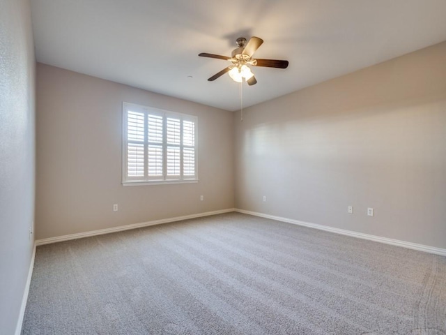 spare room with ceiling fan, carpet flooring, and baseboards