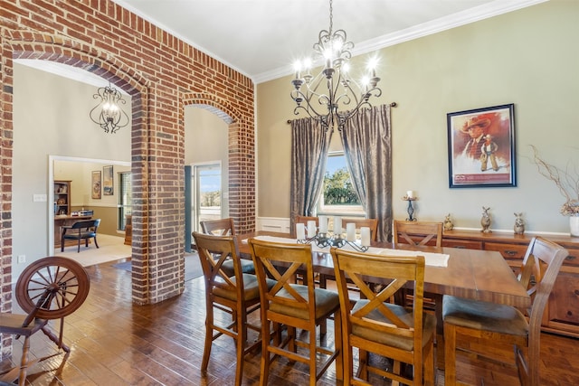 dining area with arched walkways, ornamental molding, hardwood / wood-style flooring, and an inviting chandelier