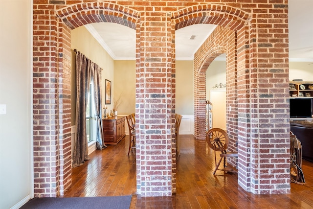 corridor with hardwood / wood-style flooring, visible vents, ornamental molding, and arched walkways