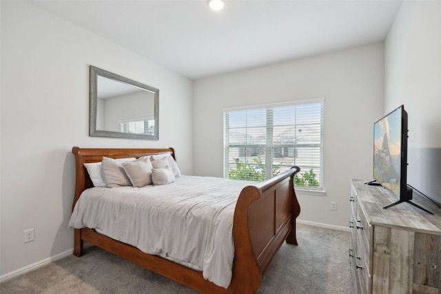 bedroom featuring light carpet and baseboards