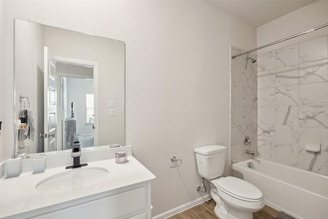 full bath featuring bathtub / shower combination, toilet, wood finished floors, vanity, and baseboards