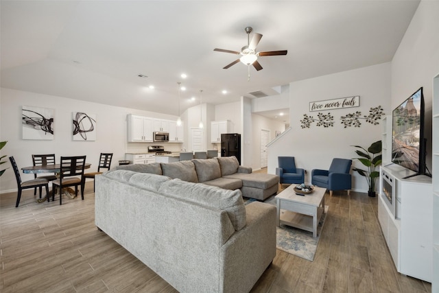 living room with baseboards, wood finished floors, visible vents, and a ceiling fan