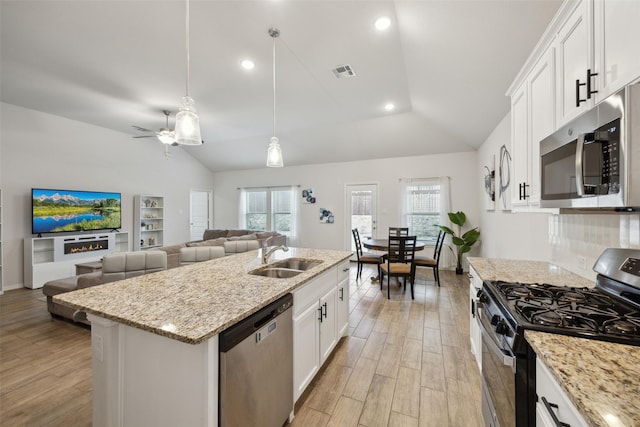 kitchen with visible vents, lofted ceiling, stainless steel appliances, light wood-type flooring, and a sink