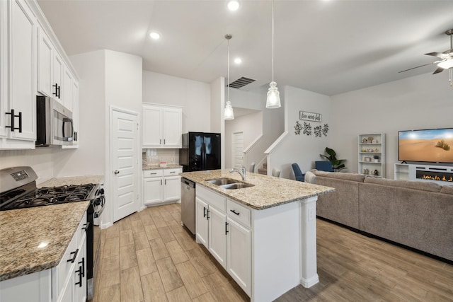 kitchen with visible vents, light wood-style flooring, appliances with stainless steel finishes, open floor plan, and a sink