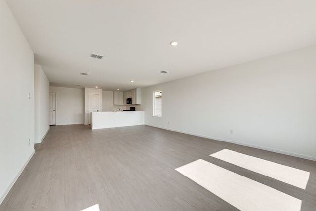 unfurnished living room featuring recessed lighting, baseboards, visible vents, and light wood finished floors