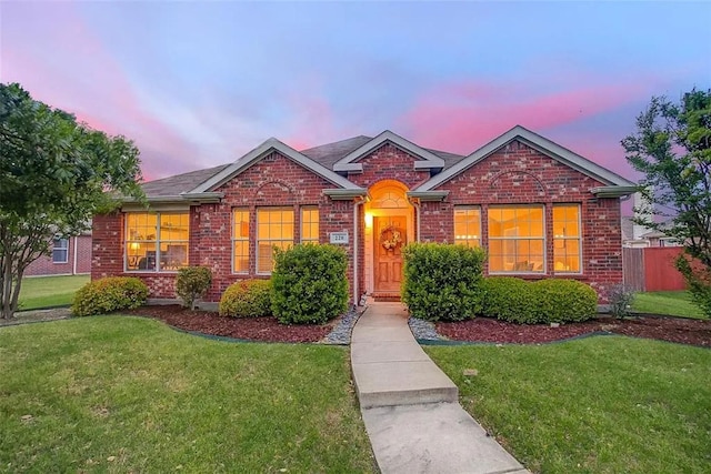 single story home featuring fence, a front lawn, and brick siding