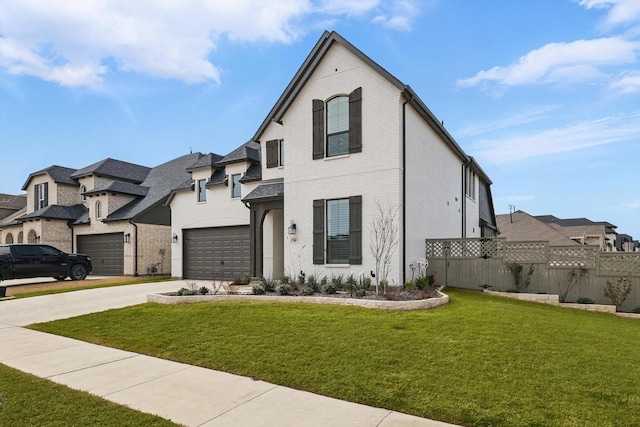 french country style house with brick siding, concrete driveway, a front yard, fence, and a garage