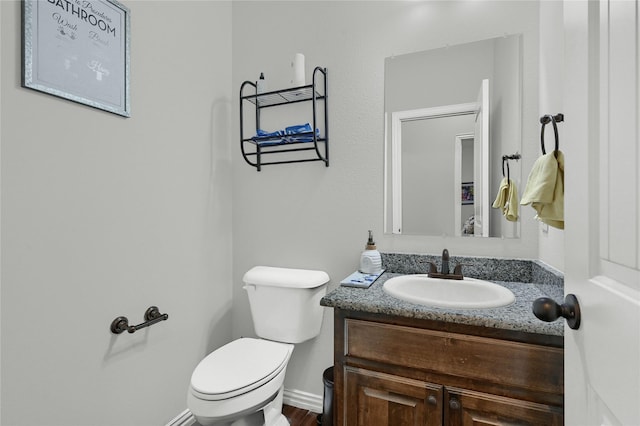 bathroom featuring vanity, toilet, and baseboards