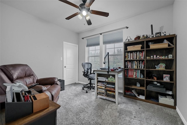 carpeted office space with ceiling fan and baseboards