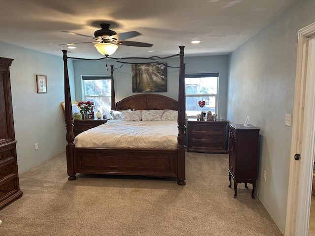 bedroom with a ceiling fan and light colored carpet