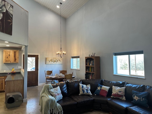 living area featuring plenty of natural light, high vaulted ceiling, and a chandelier