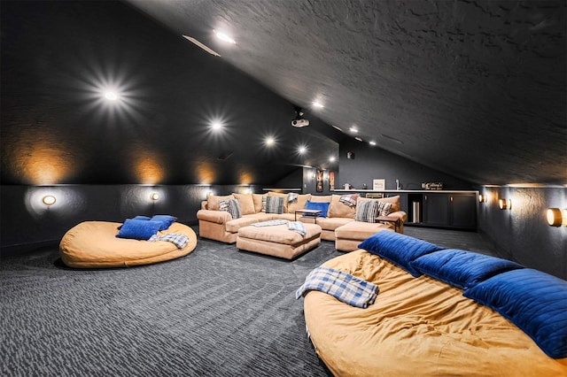 cinema room featuring carpet floors, lofted ceiling, and a textured ceiling