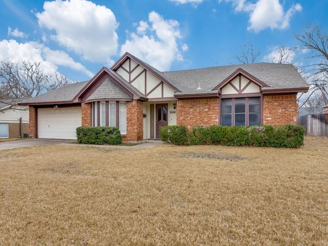 english style home with driveway, brick siding, an attached garage, and a front yard