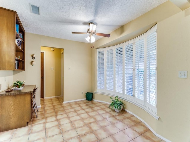 sitting room featuring ceiling fan, a textured ceiling, visible vents, and baseboards