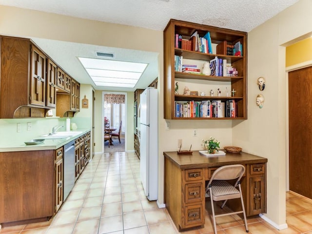 kitchen featuring open shelves, visible vents, stainless steel dishwasher, freestanding refrigerator, and a sink