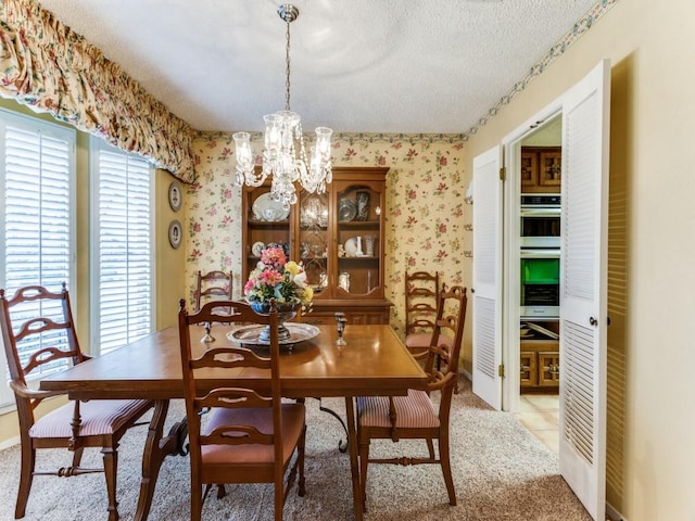 dining room with a textured ceiling, tile patterned floors, a notable chandelier, and wallpapered walls