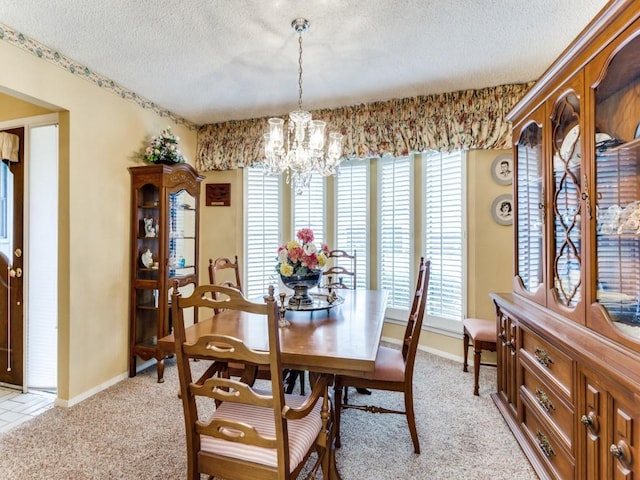 dining space with a notable chandelier, a textured ceiling, plenty of natural light, and light colored carpet