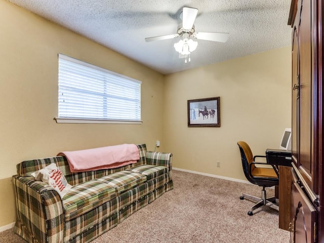 carpeted home office with a ceiling fan, baseboards, and a textured ceiling