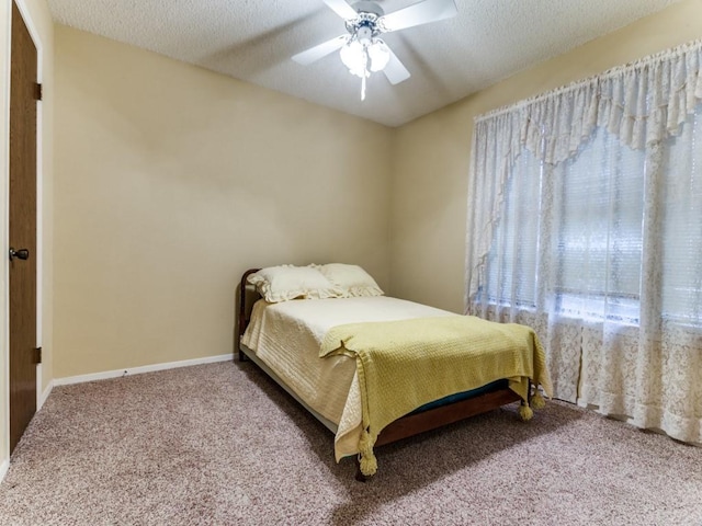 bedroom with a textured ceiling, ceiling fan, carpet flooring, and baseboards