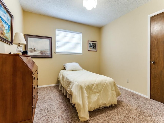 bedroom featuring a textured ceiling, carpet flooring, and baseboards