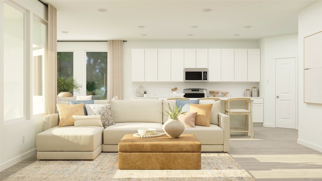 living room featuring recessed lighting, light wood-style flooring, and baseboards