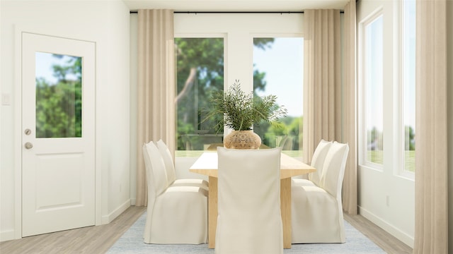 dining space featuring baseboards and light wood finished floors