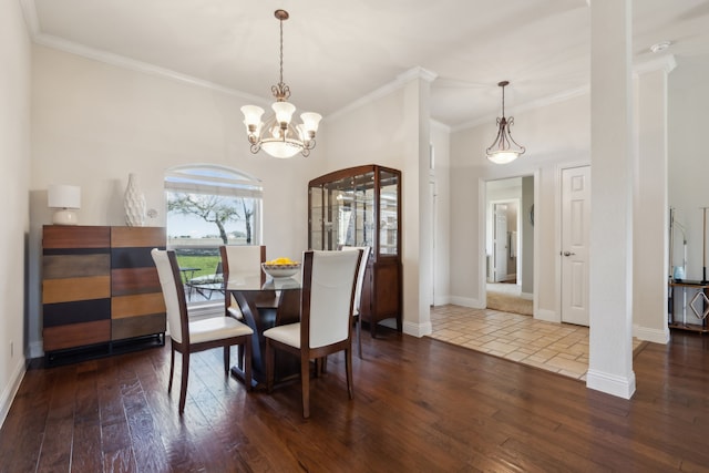 dining room with an inviting chandelier, dark wood-type flooring, crown molding, and baseboards