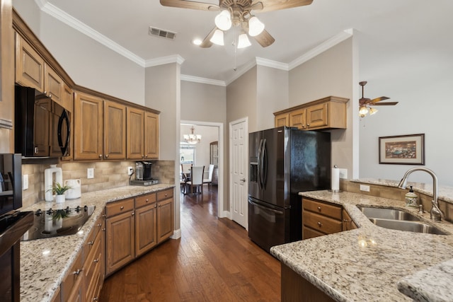 kitchen featuring visible vents, dark wood finished floors, a sink, black appliances, and backsplash