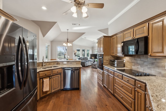 kitchen with visible vents, a sink, black appliances, open floor plan, and tasteful backsplash