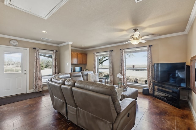 living room featuring visible vents, crown molding, baseboards, attic access, and a ceiling fan