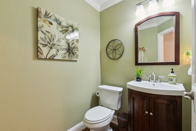 half bathroom with baseboards, vanity, toilet, and crown molding