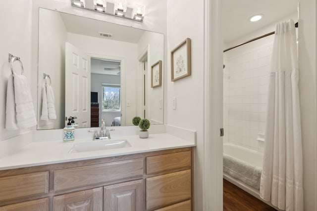 ensuite bathroom featuring visible vents, shower / bath combo with shower curtain, ensuite bathroom, wood finished floors, and vanity