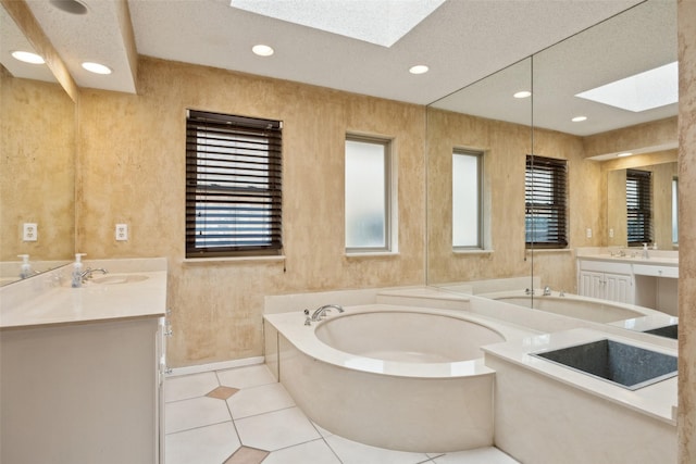 bathroom featuring a skylight, tile patterned flooring, two vanities, and a bath