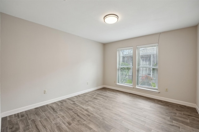 unfurnished room with baseboards and wood finished floors