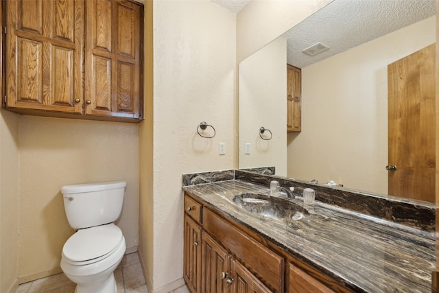 half bath featuring a textured ceiling, tile patterned flooring, toilet, visible vents, and vanity