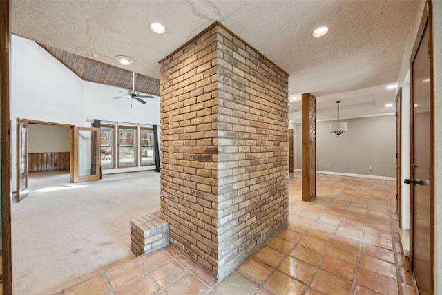 corridor with recessed lighting, light colored carpet, a high ceiling, a textured ceiling, and baseboards