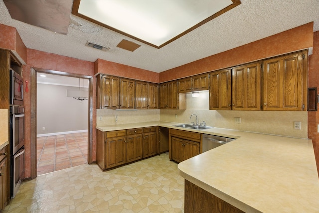 kitchen with visible vents, a sink, light countertops, a textured ceiling, and stainless steel dishwasher