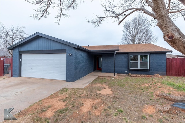 ranch-style house with brick siding, fence, driveway, and an attached garage