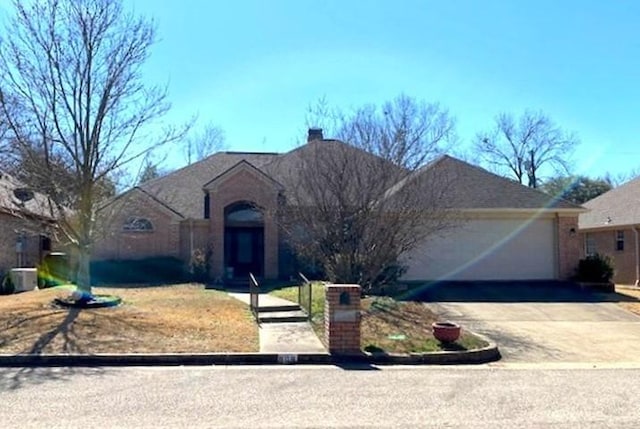 view of front of home featuring a garage, driveway, and a chimney