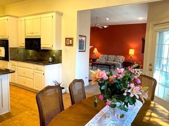 dining area featuring crown molding and light wood-style flooring